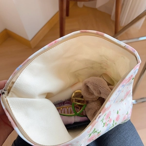 Close-up of floral cotton cosmetic bag interior showing spacious storage for hair clips
