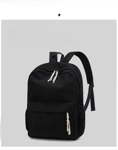 Detail of black corduroy backpack showing thick ribbed texture and white cotton zip pullers