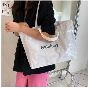 Detail of white canvas tote bag with Skillfully text and translucent PVC coating