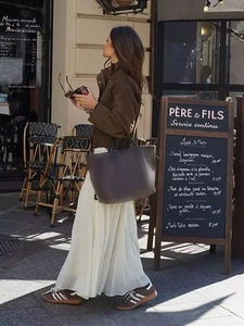 Outdoor street style featuring a brown suede biker jacket with a cream chiffon maxi skirt