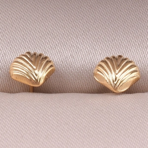 Detail of gold shell earrings with embossed texture in a champagne satin jewelry box