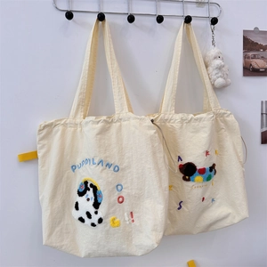 Detail of high-density canvas tote bags featuring cute puppy embroidery and drawstring closure