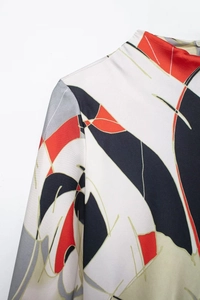 Detail of elegant satin shirt dress featuring geometric print and mandarin collar