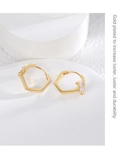 Detailed macro view of gold-plated hexagonal earrings with white zircon flower petals