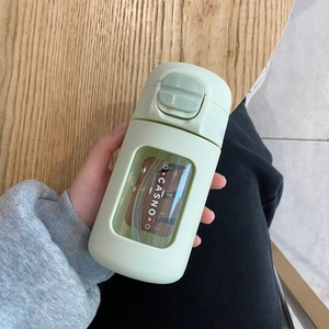 Portable green plastic tumbler with straw and push-button lid for coffee and water