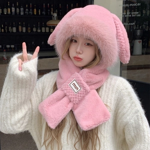Close-up detail of soft pink plush bunny ear hat and scarf set with cute embroidered label
