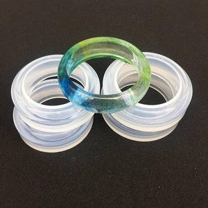 Vista macro di quattro stampi in silicone per bracciali e un bracciale in resina
