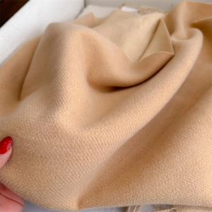 Close-up of camel cashmere-style scarf showing detailed twill weave and soft wool texture