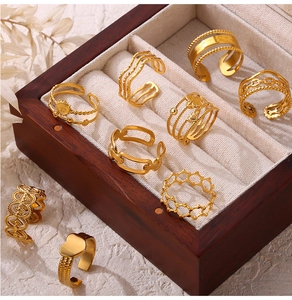 Detailed view of vintage hollow geometric gold rings arranged in a wooden jewelry box