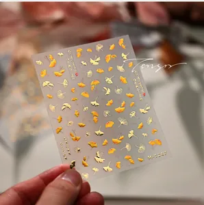 Detailed close-up of M-1247 nail stickers featuring golden ginkgo leaf patterns