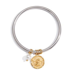 Macro detail of bicolored steel bracelet featuring angel relief coin and white pearl