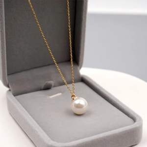 Elegante collana di perle bianche con ciondolo in oro 18 carati in una scatola di velluto