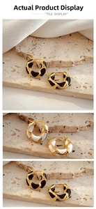 Detail view of 18K gold snake pattern hoop earrings with black and white enamel finish