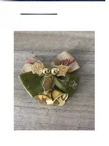 Macro view of Christmas linen bow ornament with golden bells and festive holiday text