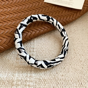 Detailed view of fashionable zebra pattern leather wrap bracelet on woven background