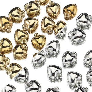 Macro shot of gold and silver heart-shaped CCB pendants for DIY jewelry crafting