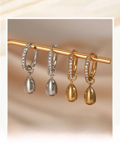 Detail view of gold and silver drop earrings with sparkling cubic zirconia on display