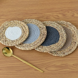 Macro detail of natural woven heat-resistant coasters with colorful center patterns