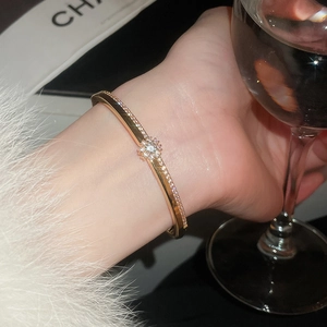 Vue détaillée d'un bracelet doré avec pavé de zircons et motif central de fleur de soleil