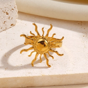 Polierter goldener Sonnenring im Retro-Ethno-Stil auf weißem strukturiertem Stein