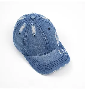 Detail of washed blue denim baseball cap showing distressed holes and vintage texture