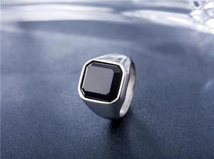 Gros plan d'une bague pour homme en argent avec onyx noir carré et fini poli