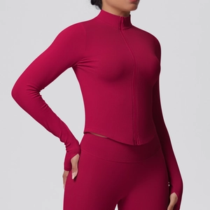 Close-up of dark red ribbed knit yoga jacket featuring thumbholes and stand collar
