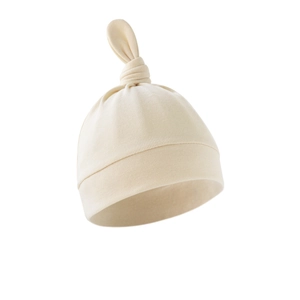 Detail view of the soft beige cotton knit fabric and top knot on this newborn baby hat