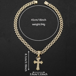 Détail du pendentif croix couronne dorée avec strass sur une chaîne à maillons cubains