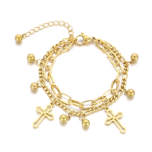 Double-layer gold stainless steel bracelet with cross and ball charms on white background