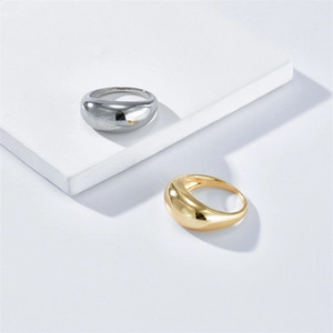 Polished chunky dome rings in gold and silver finish displayed on geometric blocks