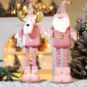 Close-up of pink Christmas plush reindeer and Santa figures with gold glitter on wood base