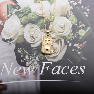 Close-up of golden necklace with cross and heart pendant on a stylish magazine
