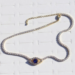 Close-up of gold choker with clear crystals and purple zircon evil eye pendant detail