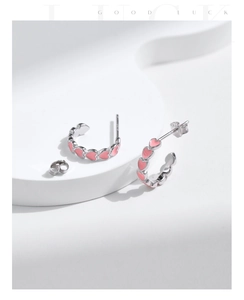 Close-up of S925 sterling silver C-shaped earrings with pink enamel hearts detail