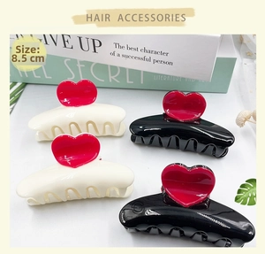 Close-up of 8.5cm heart hair clips in black and white finish with red heart detail