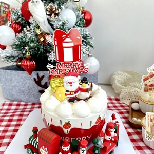 Macro detail of red Merry Christmas acrylic gift box cake topper on decorated cake