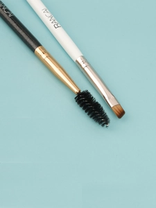 Close-up of double-ended eyebrow spoolie brush and angled eye makeup brush in detail