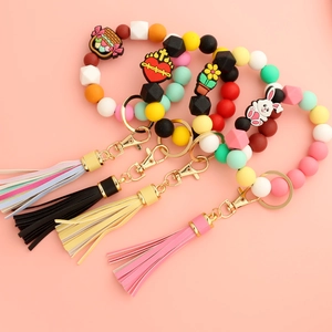 Detailed view of silicone bead wristlet keychains with leather tassels and bunny charms