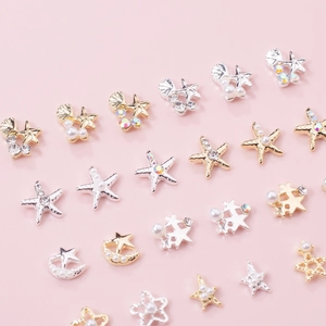 Macro shot of gold and silver nautical charms like starfish and shells for nail art
