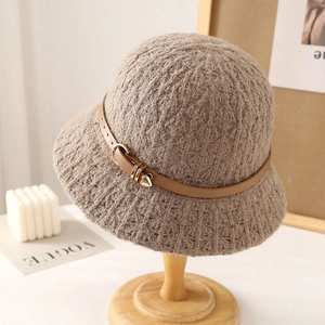 Brown textured knit bucket hat with leather belt and heart pendant on a wooden stand