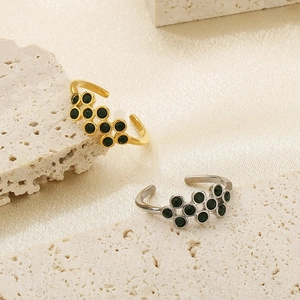 Detailed view of gold and silver titanium rings with black gemstone pavé on silk fabric