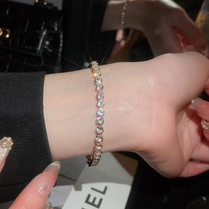 Detailed close-up of a sparkling 18k tennis bracelet featuring ruby and crystal stones