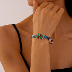 Détail d'un bracelet de luxe serti de cristaux multicolores porté au poignet d'une femme