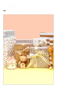 Detail of gold foil gift wrapping paper with dots, stripes and matching ribbons