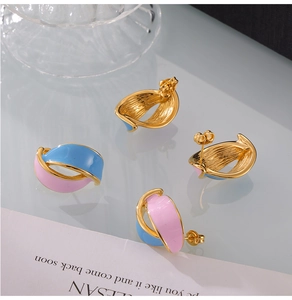 Detailed close-up of pink and blue enamel leaf earrings with elegant golden metal finish
