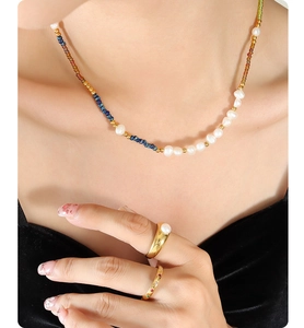 Detail of bohemian choker with colorful glass beads, freshwater pearls, and gold rings