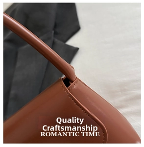 Detailed close-up of brown leather stitching and handle connection on a baguette bag