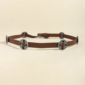 Detail of vintage brown leather belt with carved circular metal buckles and black stones