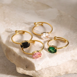 Detail of four 18k gold plated stainless steel rings with colorful oval zircon stones